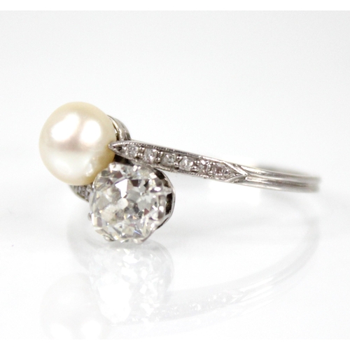 72 - An early 20th century diamond and pearl ‘moi et toi’ ring, comprising an old cut diamond measuring 5... 