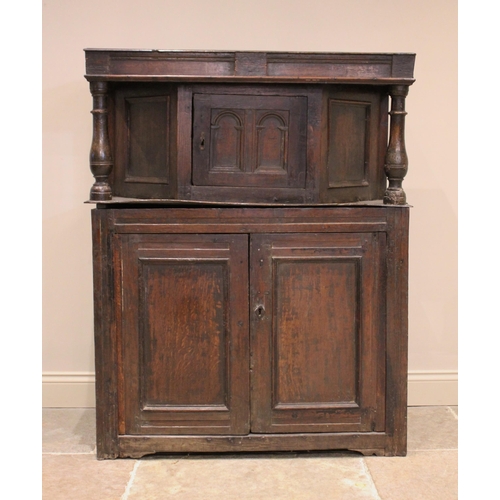 722 - An 18th century oak court cupboard, of cottage proportions, the upper section with an angular bowfro... 