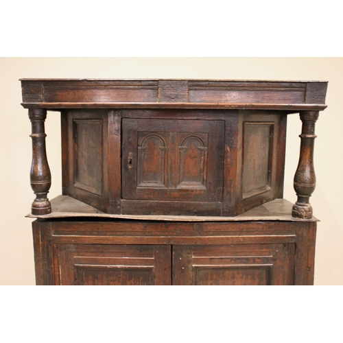 722 - An 18th century oak court cupboard, of cottage proportions, the upper section with an angular bowfro... 