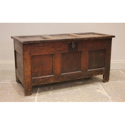 730 - An 18th century oak panelled coffer, the three panel hinged cover applied with an iron clasp lock an... 