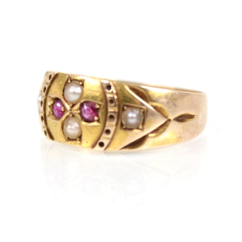 76 - A Victorian ruby and pearl 15ct gold ring, the central floral head set with two half pearls and two ... 