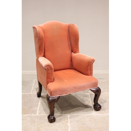 777 - A George III style wing back armchair, 19th century, upholstered in pink velour, the camel back exte... 