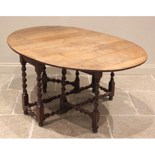 791 - A 19th century honey oak drop leaf dining table, the oval top raised upon barley twist and block sup... 