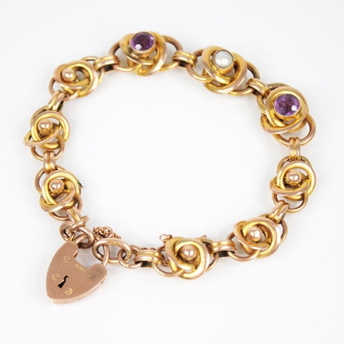 81 - An Arts & Crafts gold coloured amethyst and pearl set bracelet, designed as interwoven knot links, t... 