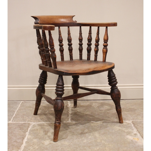 821 - A Victorian elm smokers bow elbow chair, the horse shoe shaped top rail raised upon ring turned balu... 