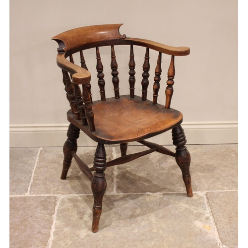 821 - A Victorian elm smokers bow elbow chair, the horse shoe shaped top rail raised upon ring turned balu... 