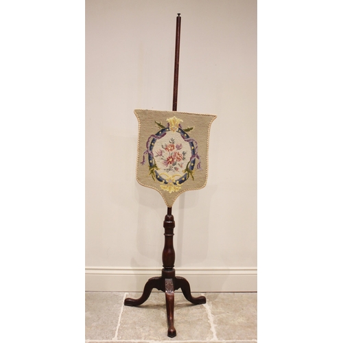 827 - A Victorian mahogany pole screen, the shield shaped floral tapestry screen upon a slender pole and t... 