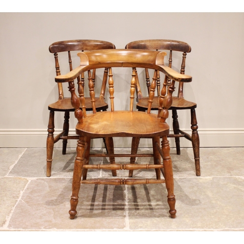 829 - A Victorian elm and beech smokers bow elbow chair, with turned spindles above a shaped seat on confo... 