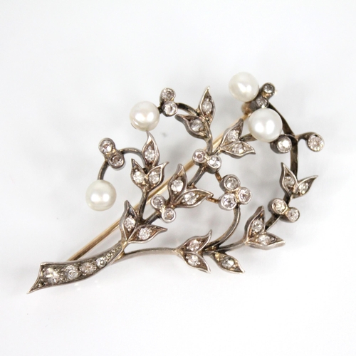 84 - An early 20th century diamond and pearl floral spray brooch, comprising four off-round pearls upon a... 