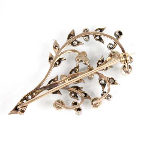 84 - An early 20th century diamond and pearl floral spray brooch, comprising four off-round pearls upon a... 