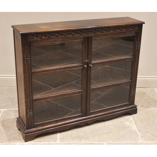 850 - An oak Priory style glazed bookcase, mid 20th century, the rectangular moulded top above a pair of g... 