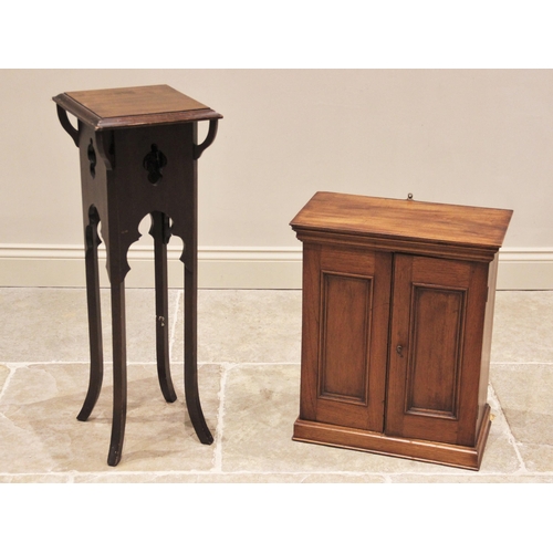 852 - An Edwardian walnut wall cabinet, with a pair of panelled doors opening to two shelves, upon a plint... 