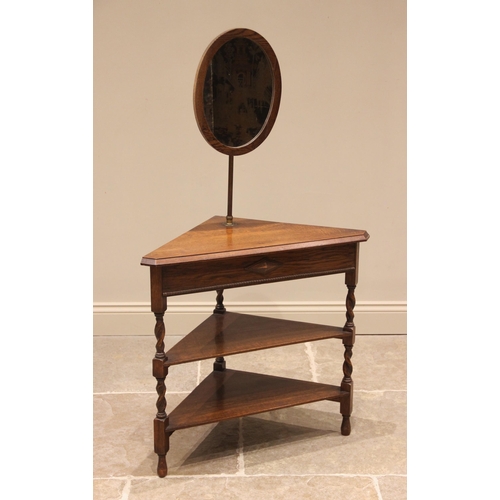 857 - An oak corner shaving stand, circa 1920, the adjustable oval mirror above three triangular tiers, up... 