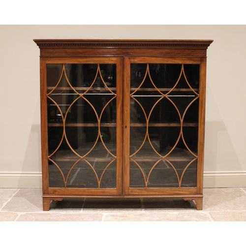 861 - A mahogany glazed bookcase, early 20th century, with a dentil cornice above a pair of astragal glaze... 