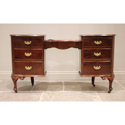 862 - An early 20th century mahogany dressing table/desk, the kidney shaped skiver inset desk top supporte... 