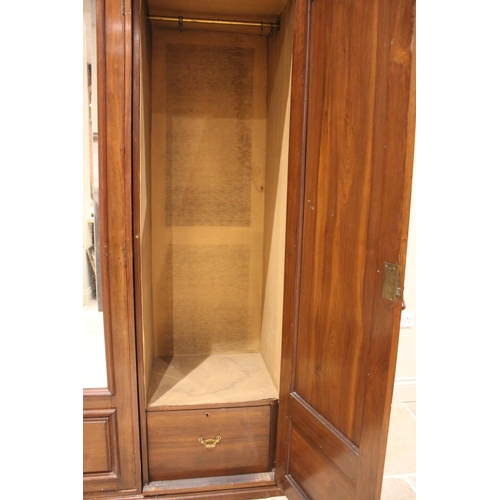 864 - A large Edwardian walnut gentleman's triple wardrobe, the central bevelled mirror door flanked by tw... 