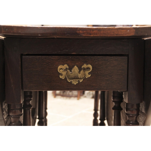 716 - An 18th century oak drop leaf dining table, the oval plank top above a single frieze drawer, upon ri... 