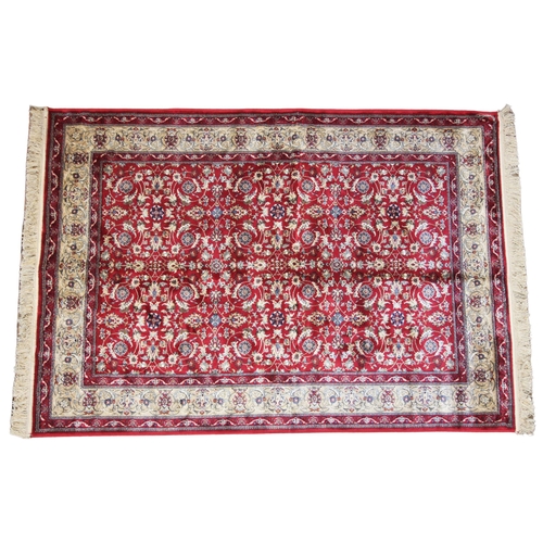 619 - A red ground Kashmir all over floral design, enclosed by a trailing border on a gold ground, 170cm x... 