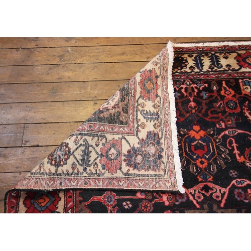 623 - A deep ground Persian Ardebil carpet, in orange, brown and red colourways, the central petal shaped ... 