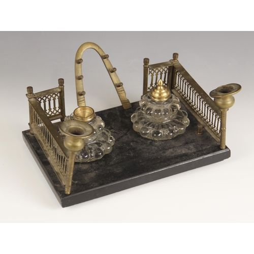 653 - A Victorian slate and brass desk stand, the pierced brass side galleries extending to candle holders... 