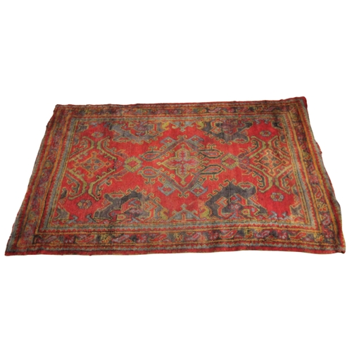 627 - A Turkish hand knotted wool rug, in red, green and blue colourways, the three open work medallions u... 