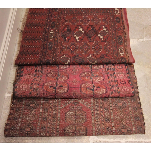 629 - Three Bokhara type rugs, each in red and black colourways with octagonal gulls to the centre field, ... 