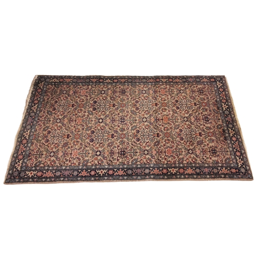 634 - A hand knotted woollen tribal rug, in red, green and brown colourways, the quarter panels with lozen... 