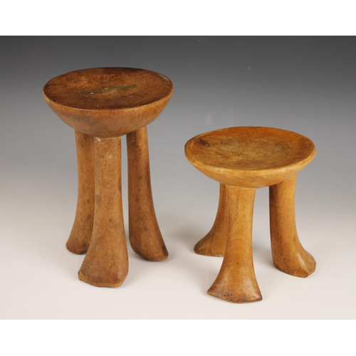 451 - Two East African Pokot stools, Kenya, each with circular seats supported by three legs, 23.5cm high ... 