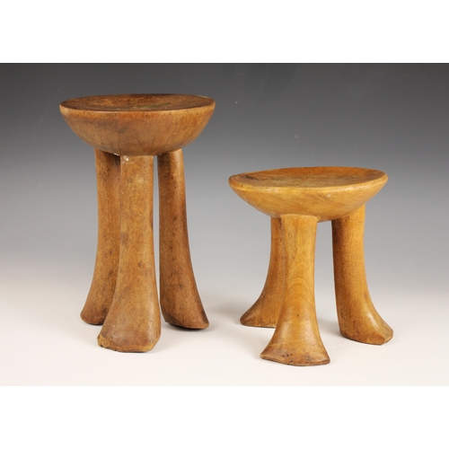 451 - Two East African Pokot stools, Kenya, each with circular seats supported by three legs, 23.5cm high ... 