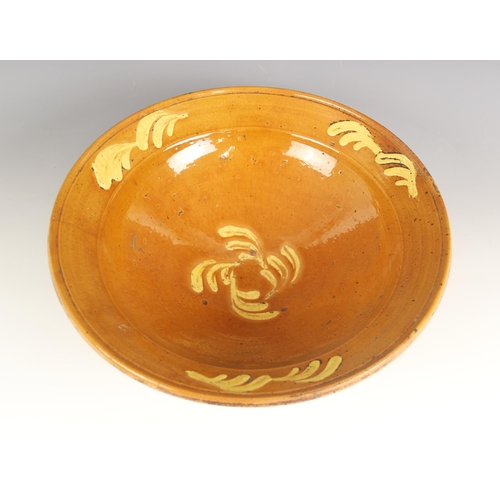 487 - A French slipware cream bowl, 19th century, the honey glazed bowl with flared rim, slip decorated wi... 