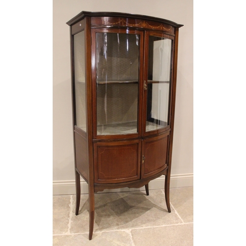 858 - An Edwardian mahogany bowfront display cabinet, the frieze inlaid with an Adam style urn and harebel... 