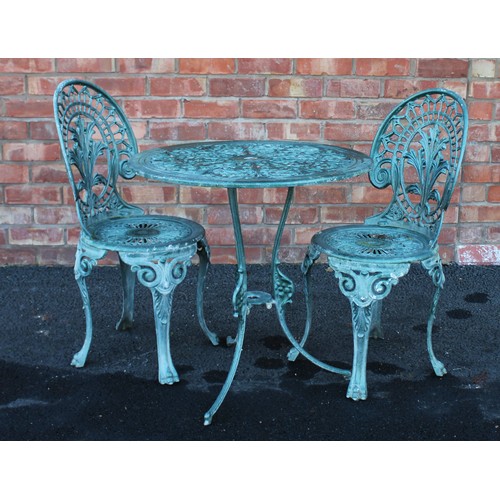 549 - A painted metal patio table and two chairs, 20th century, each chair with a cast foliate open work b... 