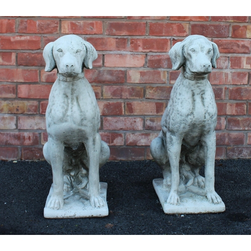 554 - A pair of reconstituted stone garden ornaments, each modelled as a seated hound upon an integrated r... 