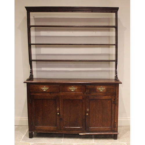 734 - An 18th century oak dresser, the open plate rack with a moulded cornice over three shelves, upon the... 