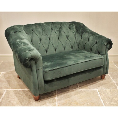 874 - A green velour two seater Chesterfield settee, contemporary, the deep set arms and button back enclo... 