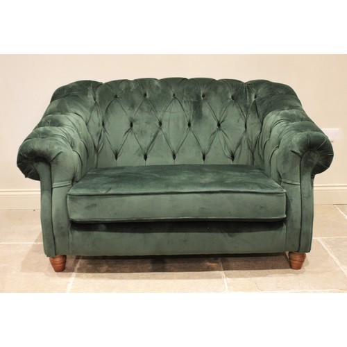 874 - A green velour two seater Chesterfield settee, contemporary, the deep set arms and button back enclo... 