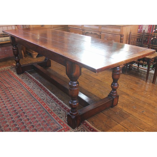 732 - A 17th century style elm refectory table, mid 20th century, the cleated three plank top upon four ba... 