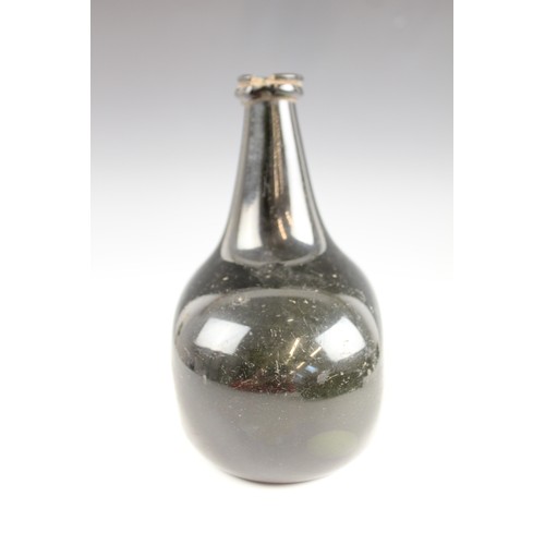 525 - An English 18th century glass wine bottle, of bladder shape and of olive green colour, 17cm high