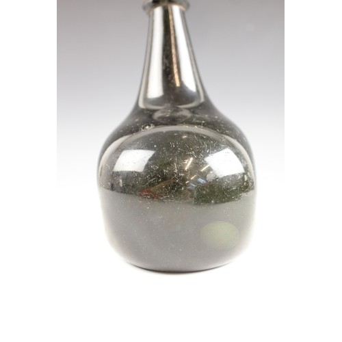 525 - An English 18th century glass wine bottle, of bladder shape and of olive green colour, 17cm high