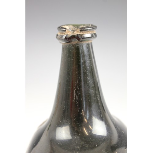 525 - An English 18th century glass wine bottle, of bladder shape and of olive green colour, 17cm high