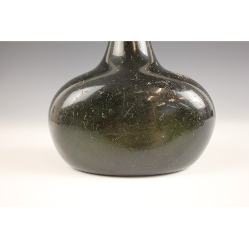 525 - An English 18th century glass wine bottle, of bladder shape and of olive green colour, 17cm high