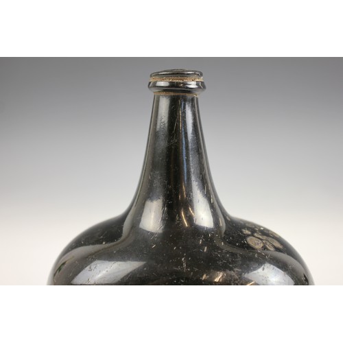 525 - An English 18th century glass wine bottle, of bladder shape and of olive green colour, 17cm high