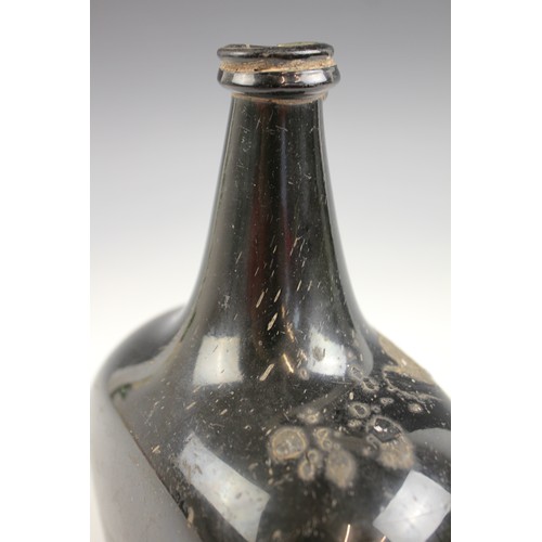 525 - An English 18th century glass wine bottle, of bladder shape and of olive green colour, 17cm high