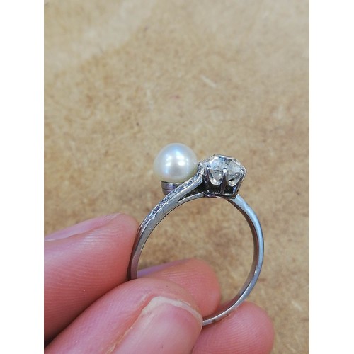 72 - An early 20th century diamond and pearl ‘moi et toi’ ring, comprising an old cut diamond measuring 5... 