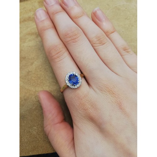 64 - A sapphire and diamond cluster ring, the central oval mixed cut cornflower blue sapphire measuring 8... 