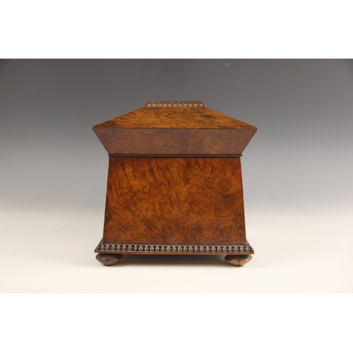 665 - A burr walnut and rosewood sarcophagus shaped tea caddy, early 19th century, the hinged cover inlaid... 