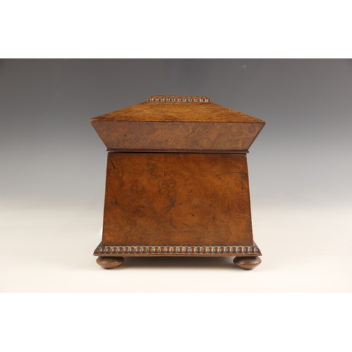 665 - A burr walnut and rosewood sarcophagus shaped tea caddy, early 19th century, the hinged cover inlaid... 