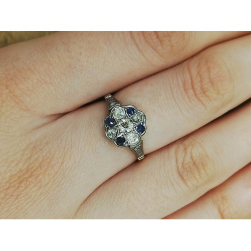 128 - An early 20th century sapphire and diamond floral cluster ring, the central floral head set with fiv... 