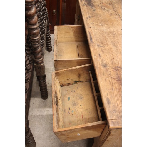 798 - A Victorian pine work bench/dresser, the plank top above three frieze drawers, upon panelled end sup... 