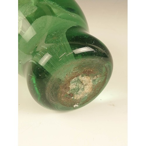 524 - Three Victorian green glass dump paperweights, late 19th century, each with floral inclusions in the... 